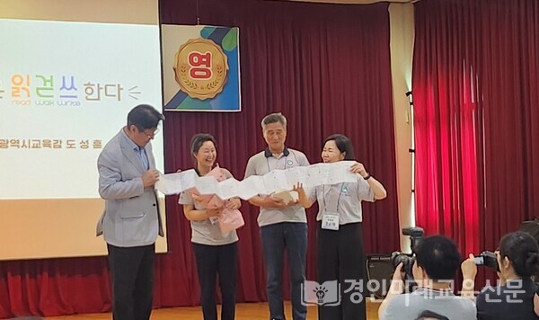 재학생들이 정성껏 쓴 손글씨 엽서를 엮은 책자를 도성훈 교육감에게 전하고 있다.